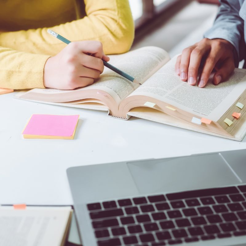 Two people looking at a textbook